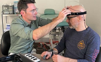 Dr David Klyne fits Wolbert van den Hoorn with a sleep monitoring device on his head